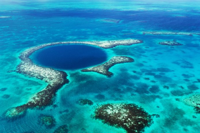 An aerial view of the coral reef and deep cave that make up the famous diving spot of the Blue Hole, Belize.