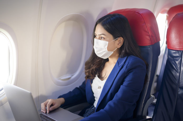 A young woman wearing face mask onboarduring covid-19 pandemic