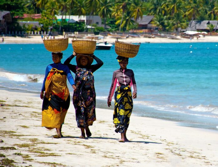 Three women walking on the beach in Madagascar.