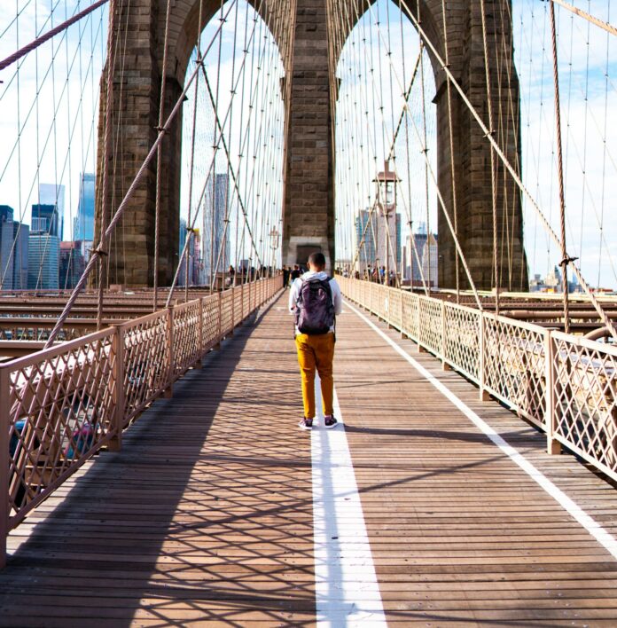 Backpacker on Brooklyn Bridge in New York City, New York.