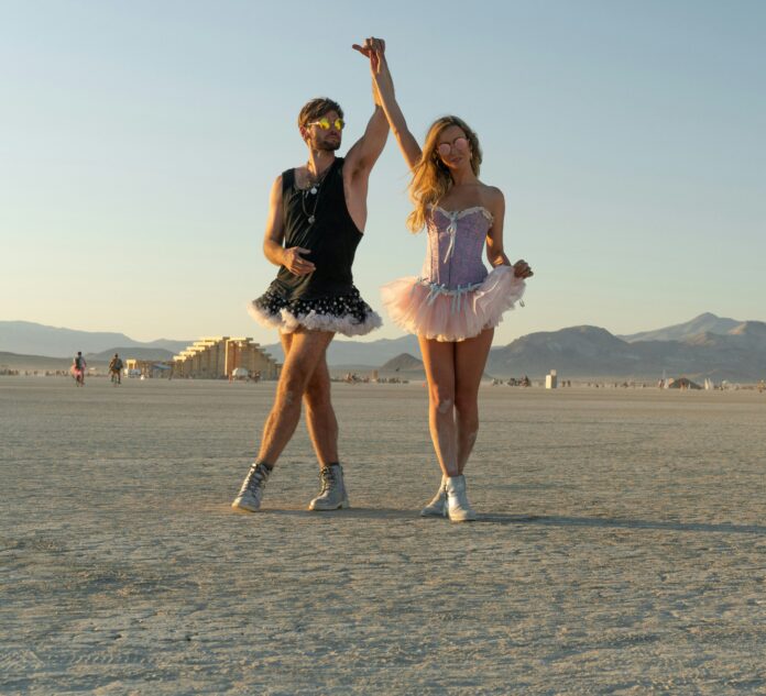 Two people wearing dresses in the desert