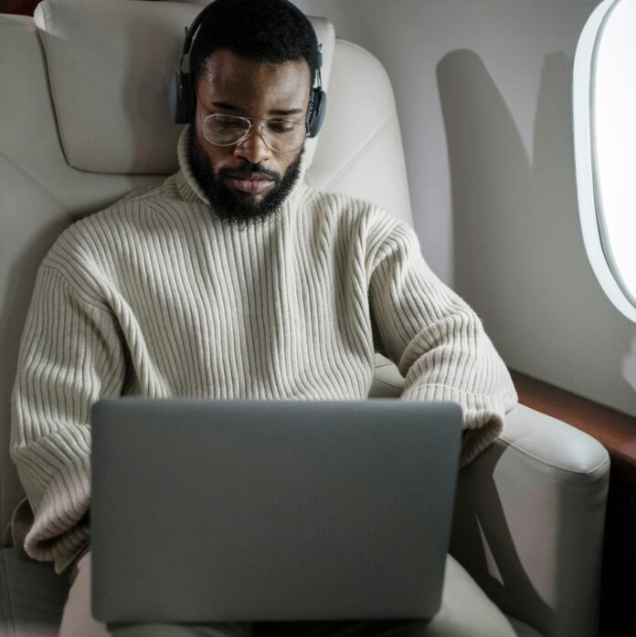Man Using his Laptop While Inside an Airplane